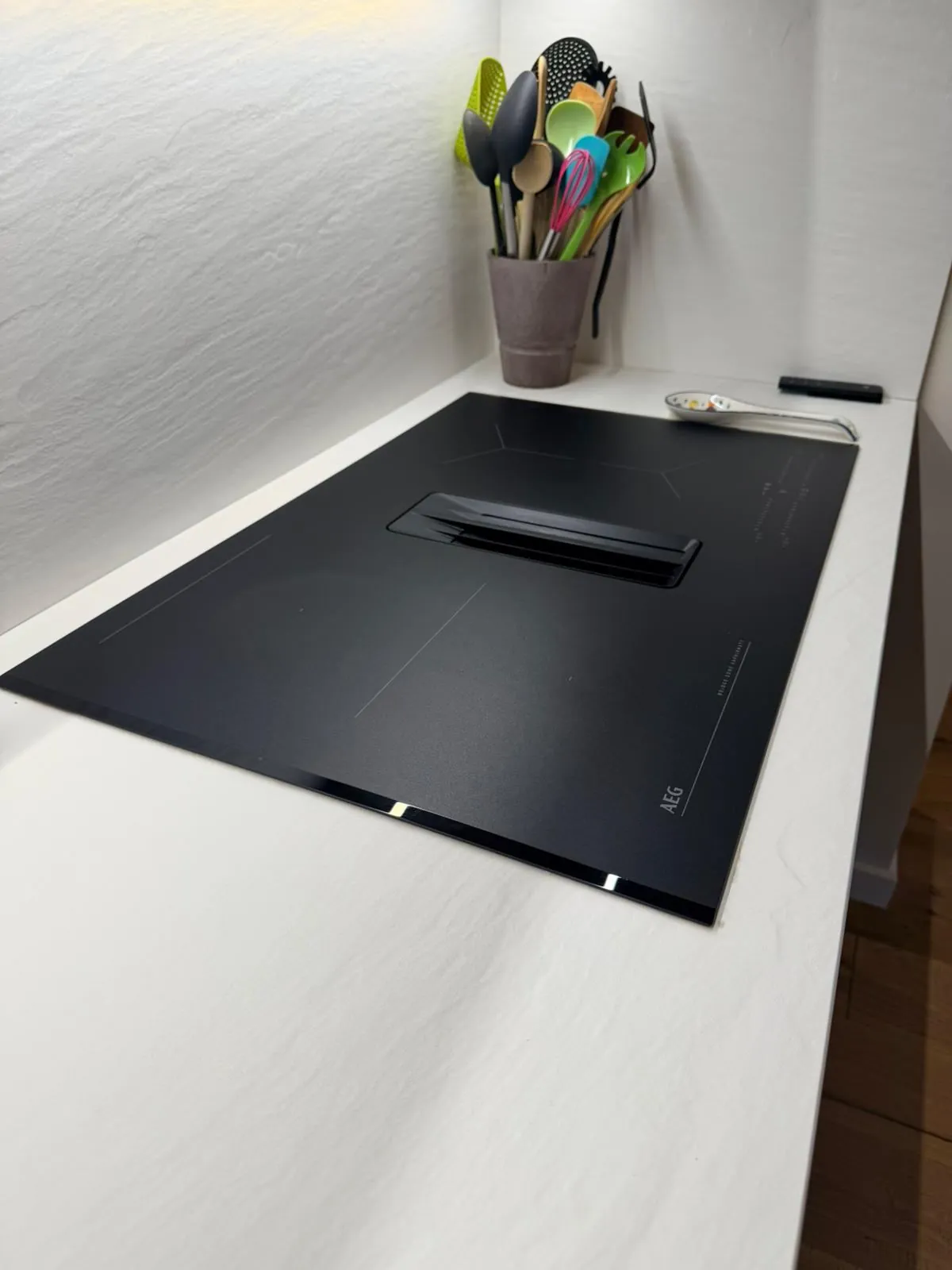 Plaque AEG à aspiration intégrée, réalisation Atelier Genèse