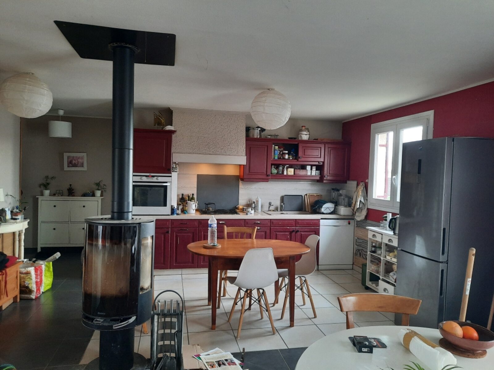 La cuisine de Véronique avant travaux : meubles bordeaux, murs aubergine, ambiance sombre et datée
